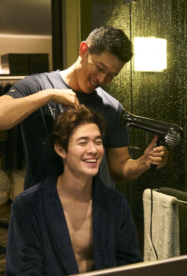 Picture depicts a hairdresser/barber styling a mans hair.